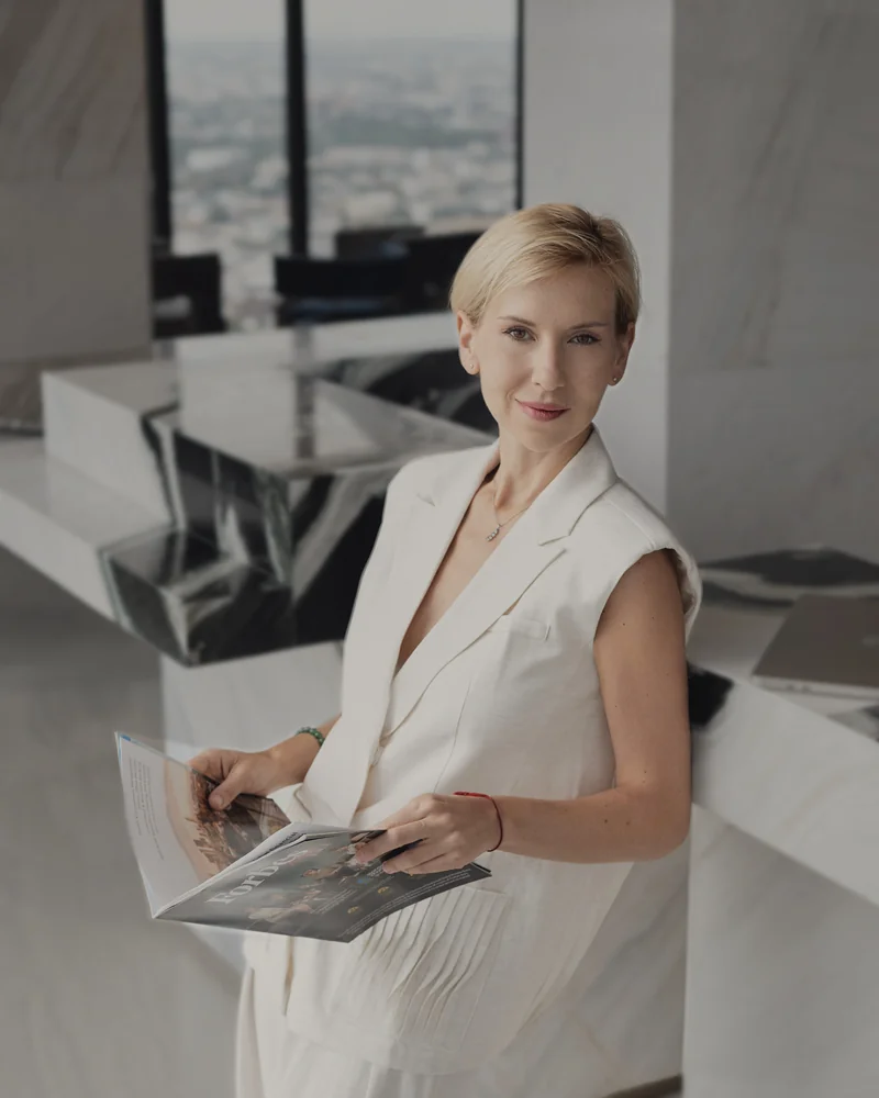 Katerina Andreeva holding an open magazine in a light interior